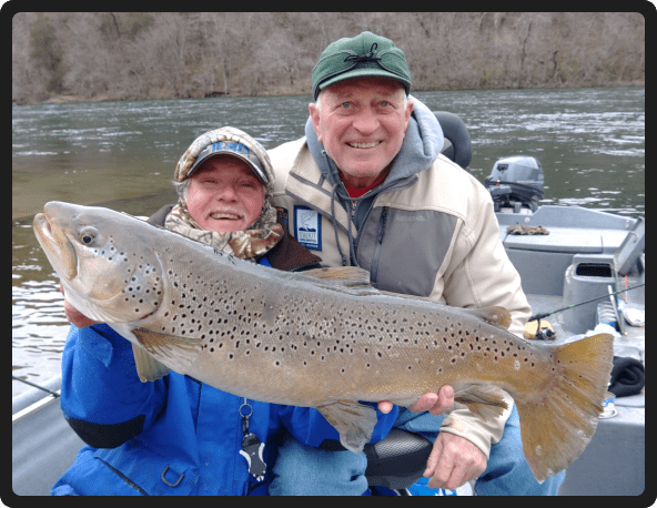 A man and woman holding a large fish.