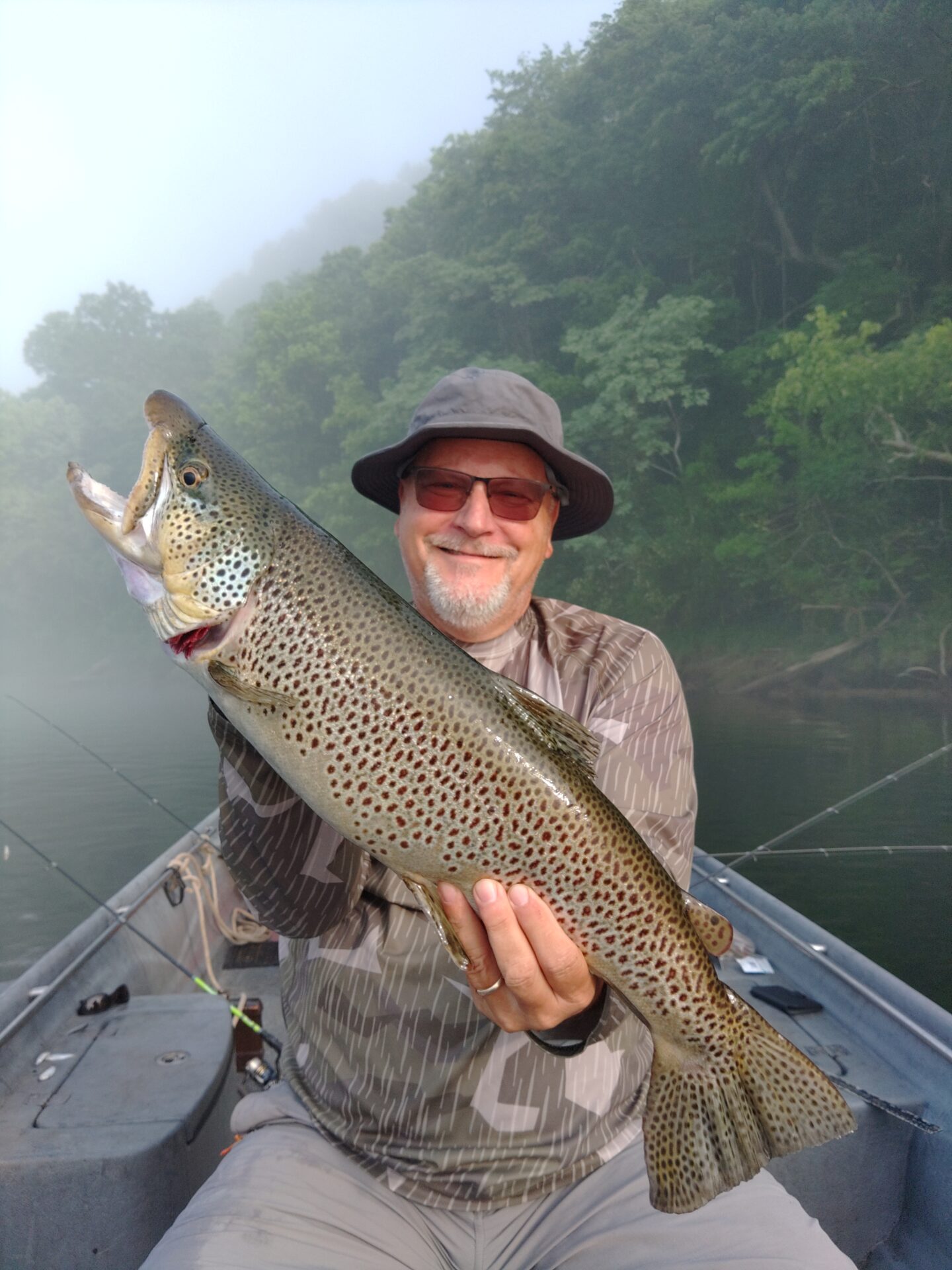 A man holding a large fish on top of a boat.